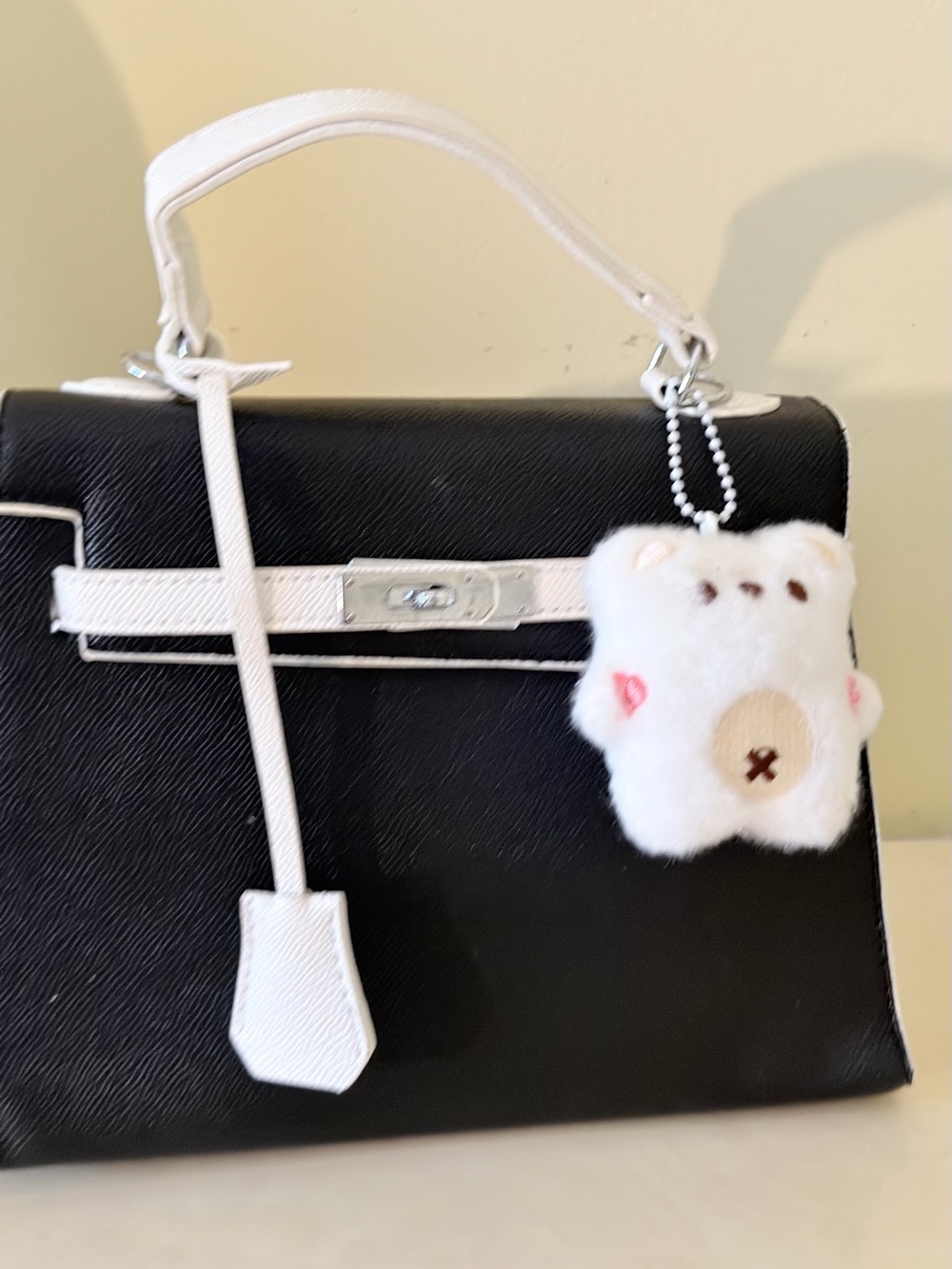 Black and White Structured Top-Handle Bag with Plush Charm